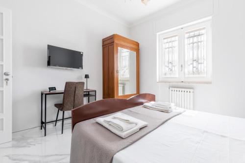 a white bedroom with a bed and a desk at House White Puglia by BarbarHouse in Fasano