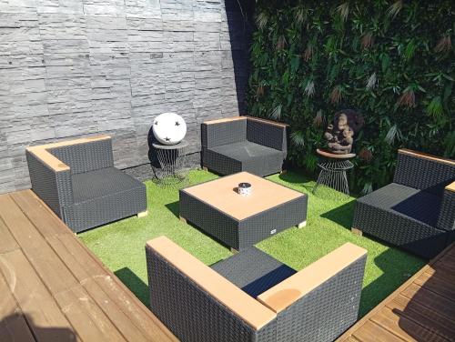 d'une terrasse avec des chaises et une table sur gazon. dans l'établissement Maison au calme située à 10 minutes des plages, à Montescot