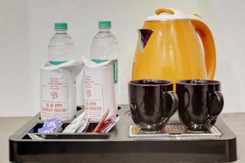 a tea kettle and cups on a tray with drinks at Hotel S B Inn Near New Delhi railway Station Paharganj in New Delhi