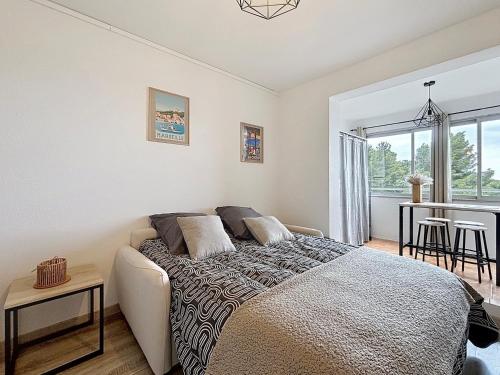 une chambre avec un lit et une table avec des chaises dans l'établissement Bay View Studio climatisé 4 pers vue mer by LaConciergerie13, à La Ciotat