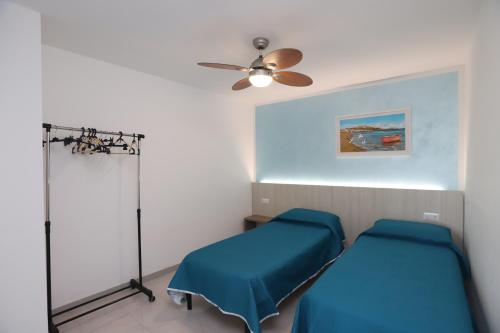 een ziekenhuiskamer met 2 bedden en een plafondventilator bij Villa Hibiscus in Vieste
