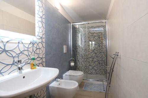 een badkamer met een wastafel, een toilet en een douche bij Villa Hibiscus in Vieste