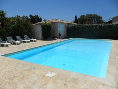 une grande piscine bleue dans une cour dans l'établissement villa Emmanuel, à Porto-Vecchio