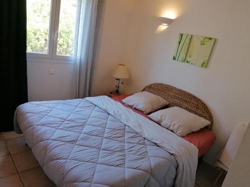 une chambre avec un lit et une fenêtre dans l'établissement villa Emmanuel, à Porto-Vecchio