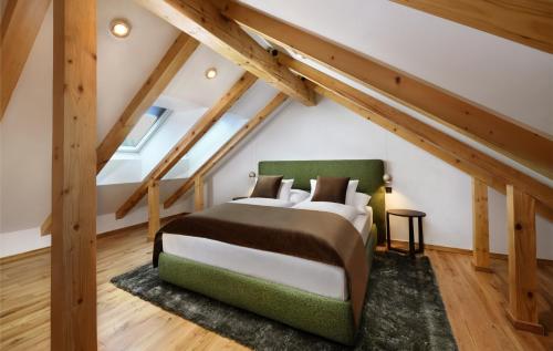 a bedroom with a large bed in a attic at Apartmány Kuszmannov bazár in Vysoké Tatry