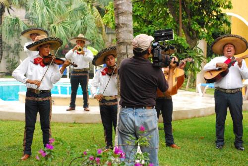 a man taking a picture of a group of people playing music at Casa Colonial Cozumel, Villa Mango in Cozumel