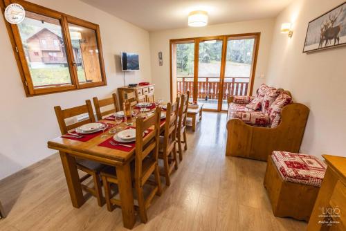 une salle à manger et un salon avec une table et des chaises dans l'établissement Le Mousqueton - 5min à pied des pistes, à Saint-Étienne-en-Dévoluy