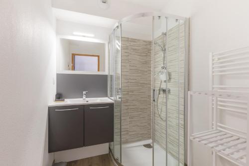 une salle de bain avec une douche en verre et un lavabo dans l'établissement Le Mousqueton - 5min à pied des pistes, à Saint-Étienne-en-Dévoluy