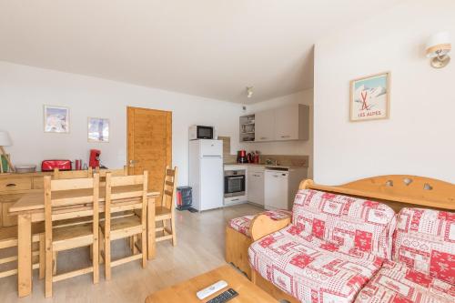 une cuisine et un salon avec une table et un canapé dans l'établissement Le Piolet - Vue montagne proche pistes, à Saint-Étienne-en-Dévoluy