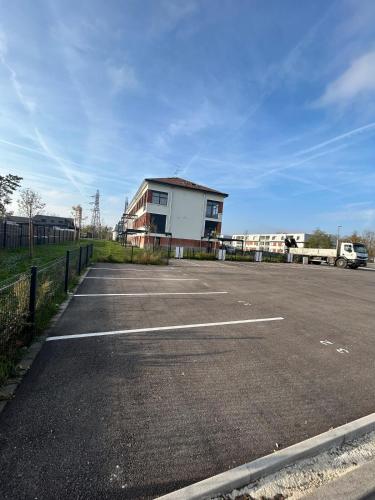 an empty parking lot with a building in the background at Studio Amélie in Wittelsheim