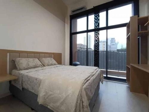 Un dormitorio con una cama y una ventana grande. en Aimbere by You - 20015 - Ótima localização - Allianz Parque - Palmeiras - Perdizes, en São Paulo