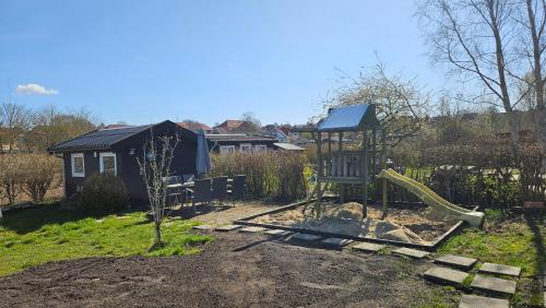 a playground with a slide in a yard at Billig og Hyggelig Overnatning i Skive Cheap and Cozy Accommodation No 34 in Skive