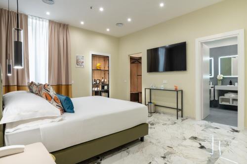 a bedroom with a large white bed and a flat screen tv at 69 Suite Boutique in Rome