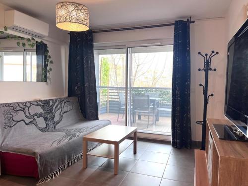 un salon avec un canapé et une table dans l'établissement Bel appartement avec terrasse en bord de mer, à Mauguio