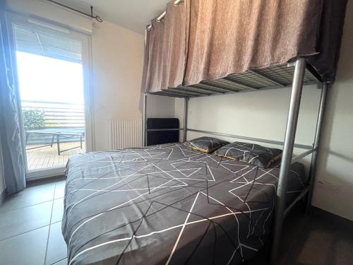 une chambre avec un lit superposé et une fenêtre dans l'établissement Bel appartement avec terrasse en bord de mer, à Mauguio