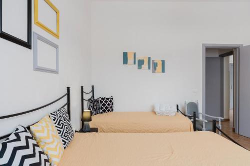 two beds in a room with white walls at Casa Petros in Marsala