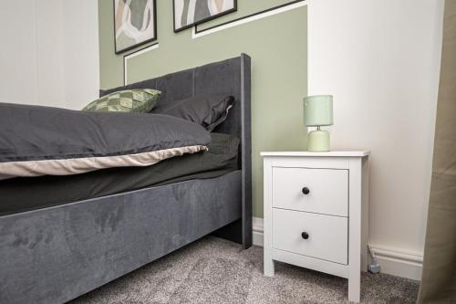 a bedroom with a bed and a night stand with a lamp at Bright Key Stays - The Lincoln Lodge at Spa Street in Lincoln