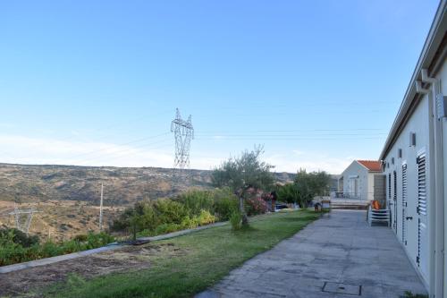a sidewalk next to a building with a view of a hill at Douro Natura in Bemposta