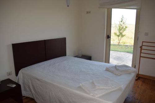 a bedroom with a white bed with two towels on it at Douro Natura in Bemposta