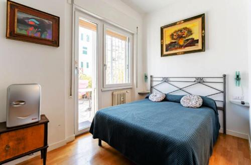 une chambre avec un lit bleu et une télévision dans l'établissement Alloggio Turistico via dei Faggi - Room, à Rome