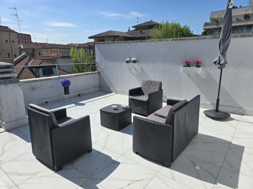 a patio with two chairs and an umbrella on a roof at Bilocale 40 mq con parcheggio privato in Milan