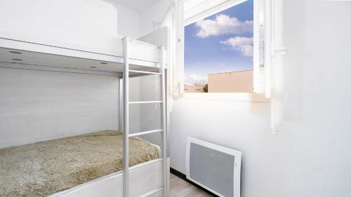 une chambre avec un lit superposé et une fenêtre dans l'établissement La Dune N64 Villa 3P6, à Sérignan
