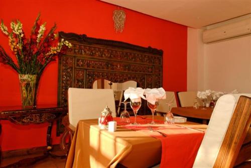 a dining room with a table and a red wall at Hotel Brajas in Antananarivo