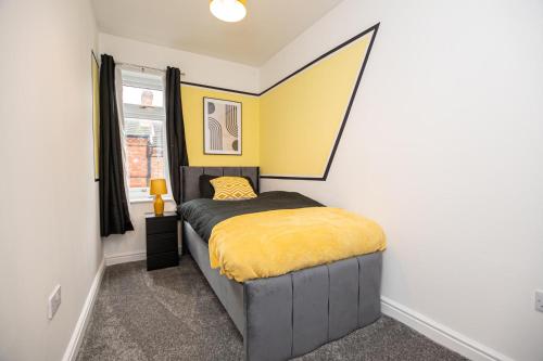 a bedroom with a bed with a yellow blanket at Bright Key Stays - The Lincoln Lodge at Spa Street in Lincoln