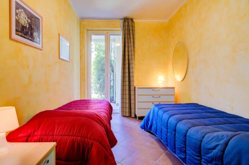 1 Schlafzimmer mit 2 Betten, einer Kommode und einem Fenster in der Unterkunft Azzurro Apartment in Padenghe sul Garda