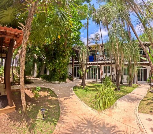 an exterior view of a house with palm trees at Apart Hotel Casaejido in Playa del Carmen