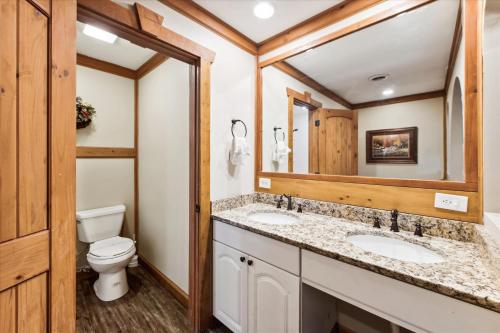 een badkamer met 2 wastafels en een toilet bij Beautiful Lofted Condo, Centrally Located in Gatlinburg