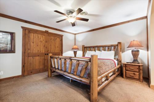een slaapkamer met een houten bed en een plafondventilator bij Beautiful Lofted Condo, Centrally Located in Gatlinburg