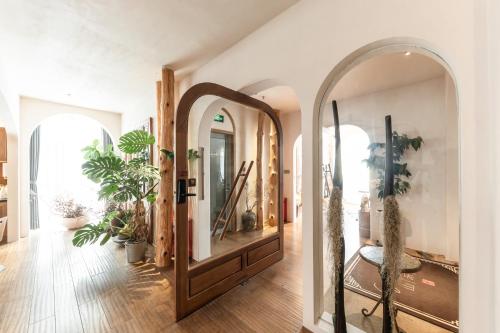 a hallway with a large mirror and potted plants at Shanheli Chaji Aesthetic Hotel Mixc Branch in Shantou