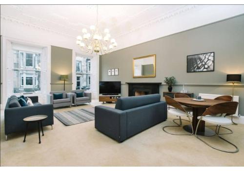 a living room with a blue couch and a table at JOIVY Elegant New Town Flat near Princes Street in Edinburgh