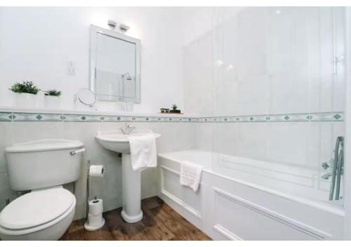 a white bathroom with a toilet and a sink at JOIVY Elegant New Town Flat near Princes Street in Edinburgh