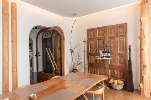 a dining room with a table and a wooden door at Shanheli Chaji Aesthetic Hotel Mixc Branch in Shantou