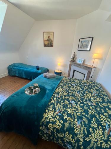 une chambre avec un grand lit avec une couette bleue dans l'établissement Le Duplex de Saint Jacques, à Dieppe