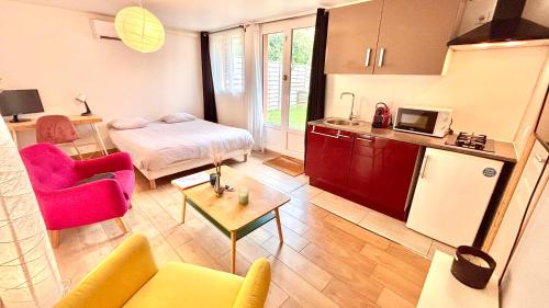 a living room with a bed and a kitchen at SECRET GARDEN parking hyper centre & calme in Claye-Souilly