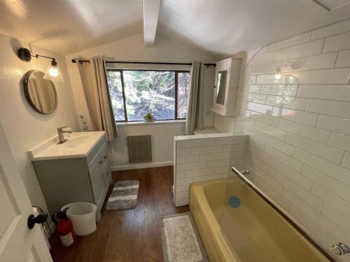 a bathroom with a tub and a sink and a mirror at Walking Distance To The Lake And Beach! in Kings Beach