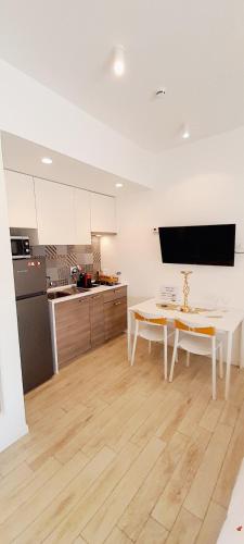 a kitchen with a table and a kitchen with a refrigerator at BARBARA Classy Apartments 103, Wellness in Siracusa