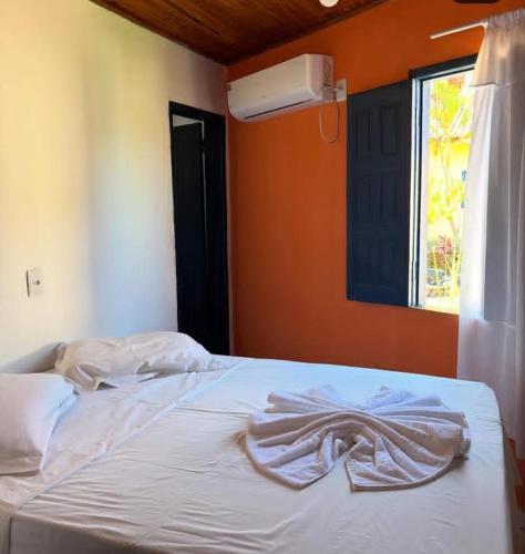 a white bed with a blanket on it in a bedroom at Pousada Brilho da Chapãda in Lençóis