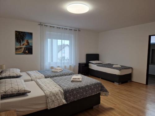 a bedroom with three beds and a window at Patricia House in Ljubljana