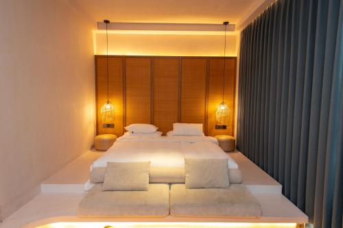 a bedroom with a large bed with two pillows at Shanheli Chaji Aesthetic Hotel Mixc Branch in Shantou