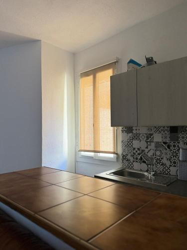 une cuisine avec un comptoir et une fenêtre dans l'établissement Azur Sigean, à Sigean