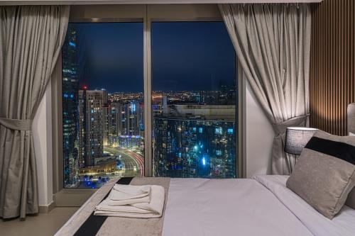 a bedroom with a large window with a city view at Desert Key - Platinum Apartments in Gate Tower, Al Reem Island in Abu Dhabi