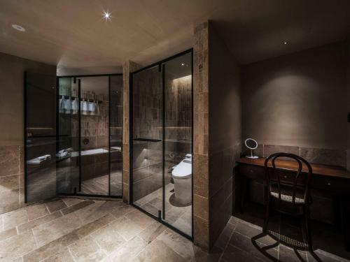 a bathroom with a toilet and a glass shower at Jingdezhen Xingshan City outside Jielu Hotel in Jingdezhen