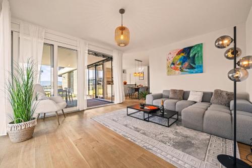 a living room with a couch and a table at STAYS Werft - Luxus in erster Seereihe in Kressbronn am Bodensee