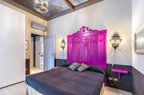 1 dormitorio con armario rosa en una habitación en Dimora DellAntico Convento, en Alba
