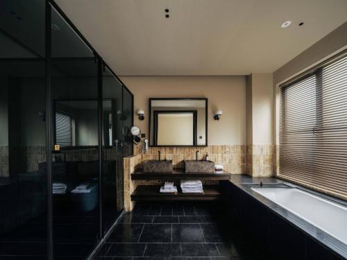 a bathroom with a tub and a sink and a mirror at Jingdezhen Xingshan City outside Jielu Hotel in Jingdezhen