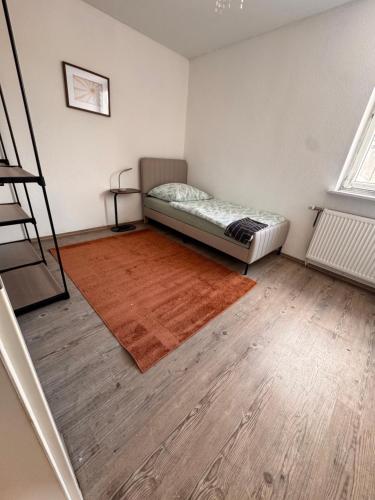 a bedroom with a bed and a wooden floor at A&V Apartments Iserlohn Kiki Karl-Arnold in Iserlohn